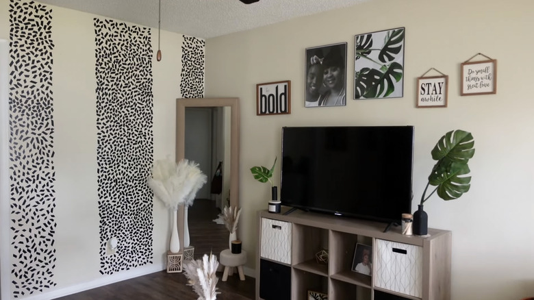 Small pieces of black electrical tape create bold stripes on a living room accent wall