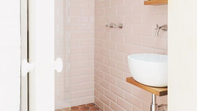 bathroom with pink subway tile and floating vessel sink
