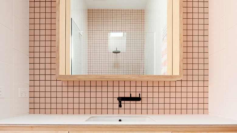 bathroom with pink mosaic tile and floating vanity