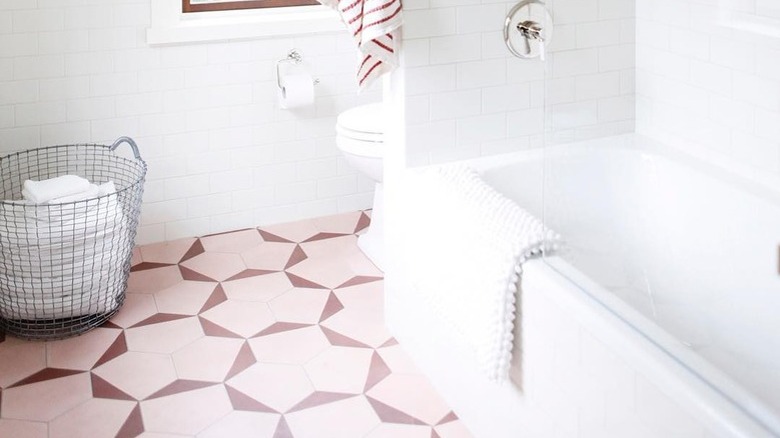 A bathroom with pink tile accents