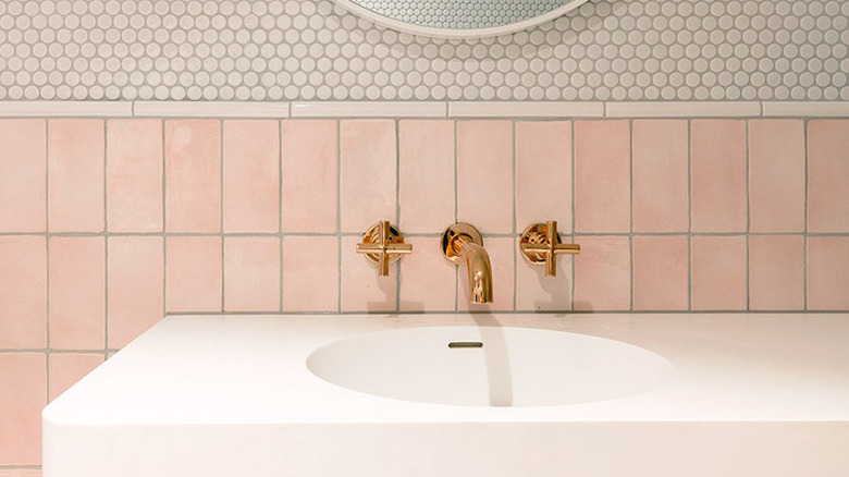 bathroom with pink tile wainscot and round penny tile
