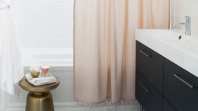 A bathroom with a pink shower curtain