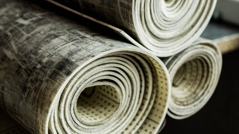 Rolls of linoleum flooring are stacked on each other