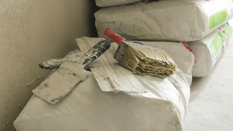 Dirty tools sit on a bag of grout