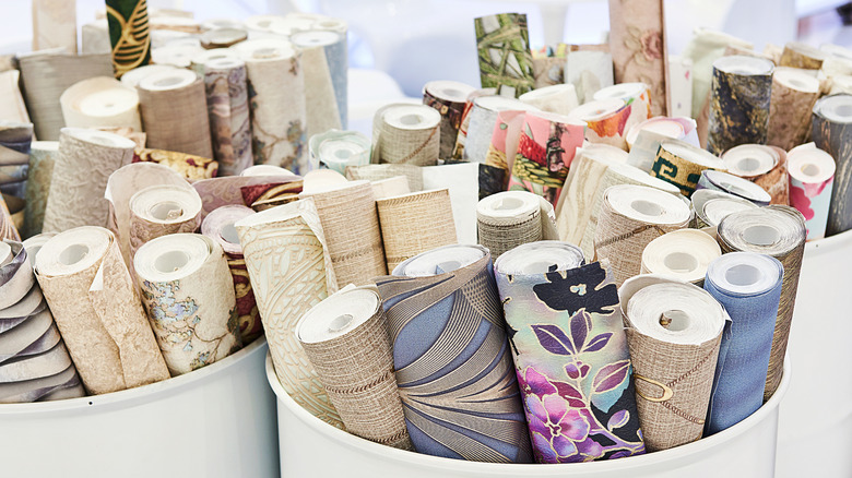 Rolls of wallpaper are stored upright in barrels