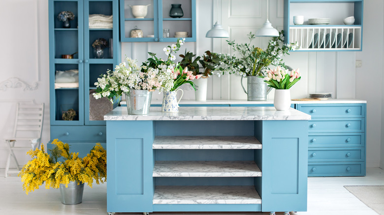Kitchen with baby blue cabinets on the island and main bank