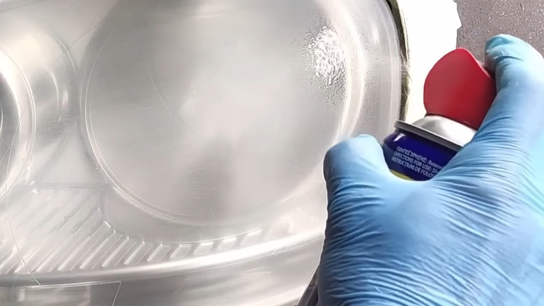 Spraying a hazy headlight lens with WD-40