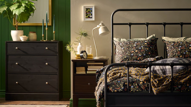 A moody green and taupe bedroom has a bed dressed with IKEA's BRUDKRUSBÄR Duvet cover and pillowcases