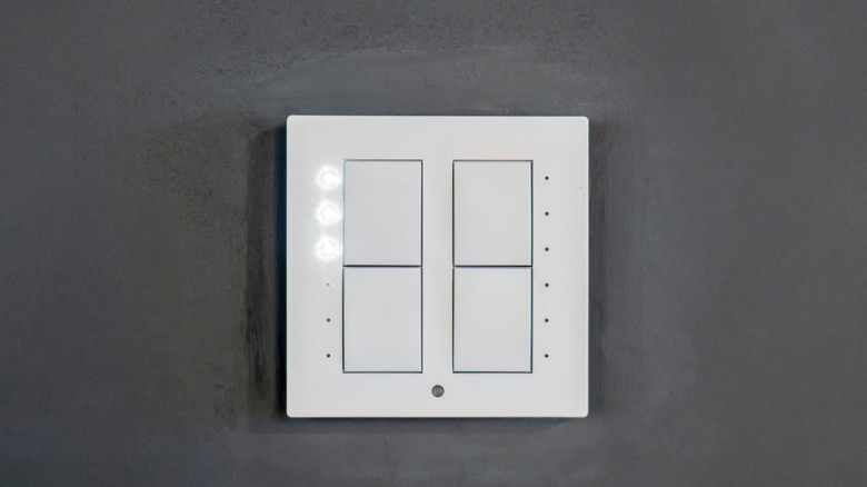 A four-button smart switch mounted within a wall