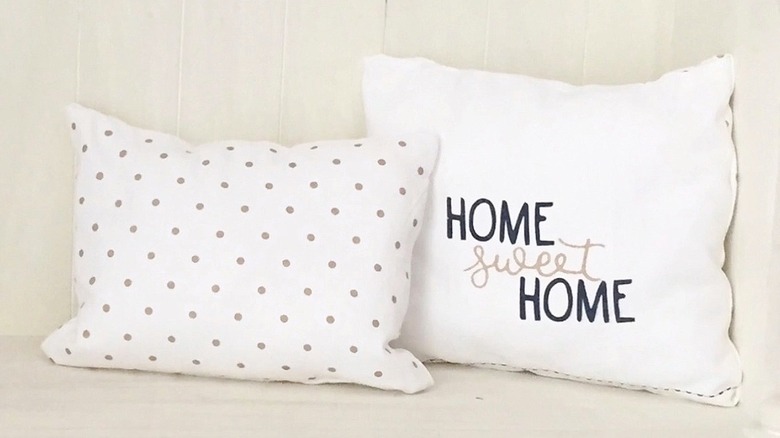 Two pillows made from tea towels beside a small tree