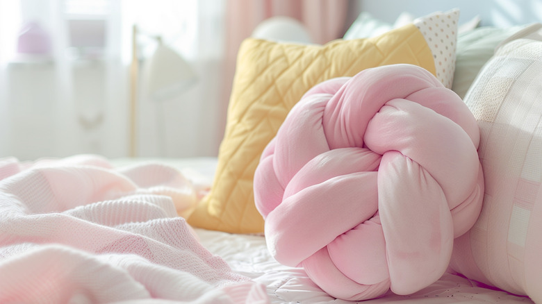 Large towel turned into a pretzel-knot throw pillow