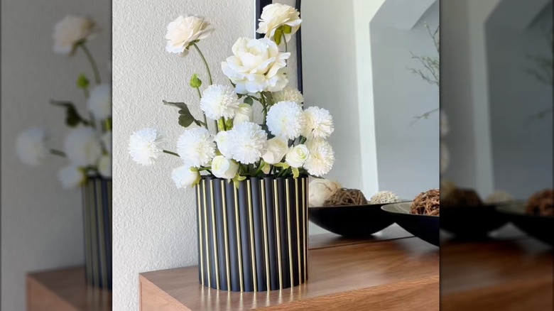 DIY modern glam vase with white carnations, marigolds, and roses on stylish wood table