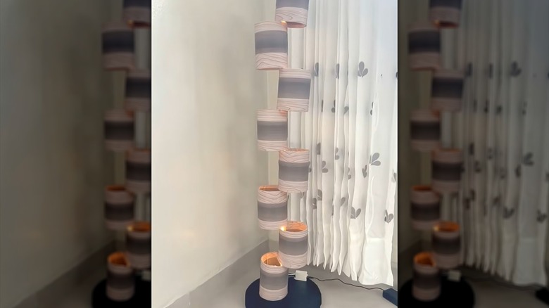 Repurposed PVC pipes as contemporary tiered lamp in bedroom corner