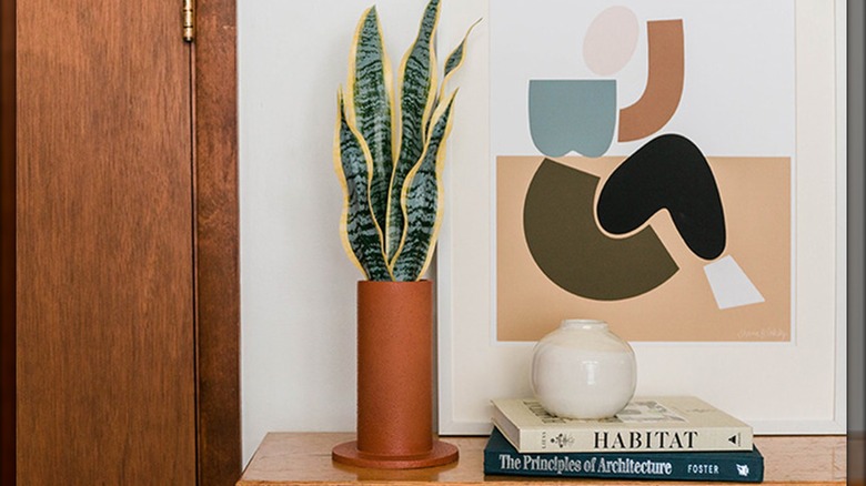 Terracotta-style PVC pipe planter with artificial snake plant beside contemporary decor