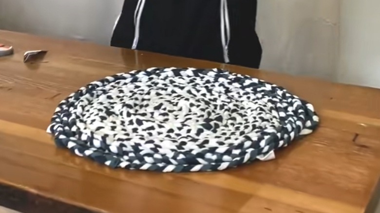 Black and white mini rug made from woven T-shirt pieces on wood table