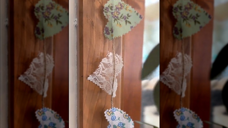 Floral and lacey clothing fabric transformed into garland on twine string