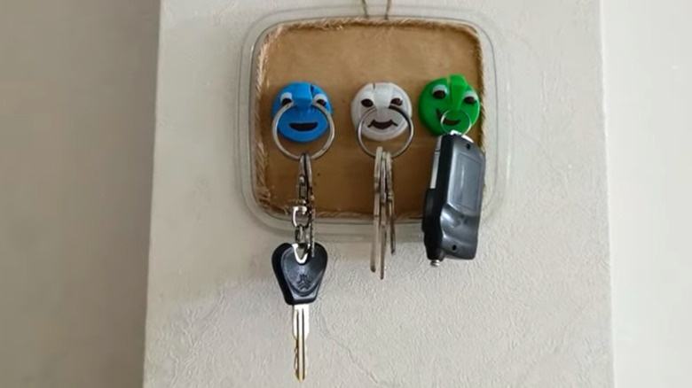 Key hook station with plastic lid backing