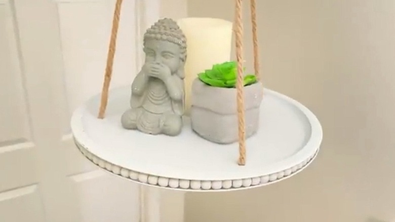 Hanging shelf made from flat discs and rope