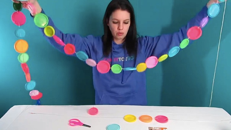 Making garland from Play-Doh lids