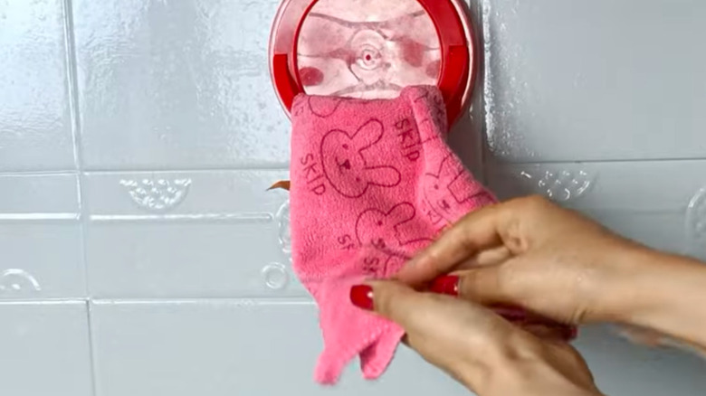 A towel ring made from a red plastic lid