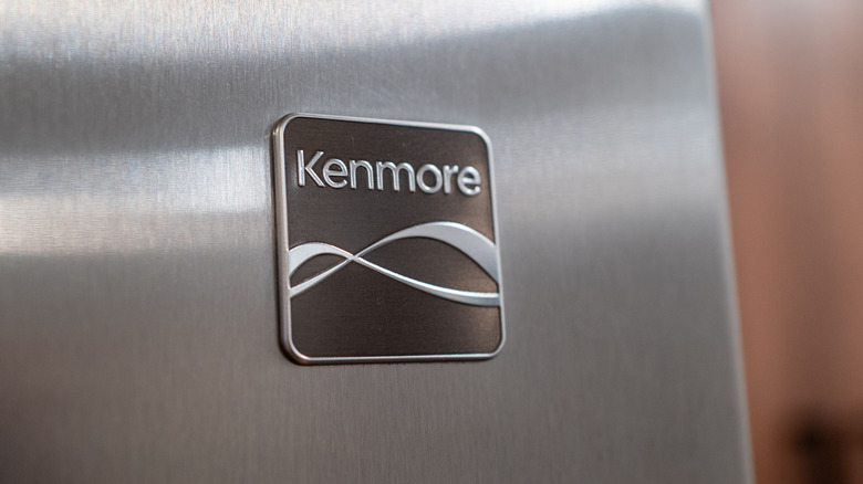 A Kenmore logo on a stainless steel refrigerator
