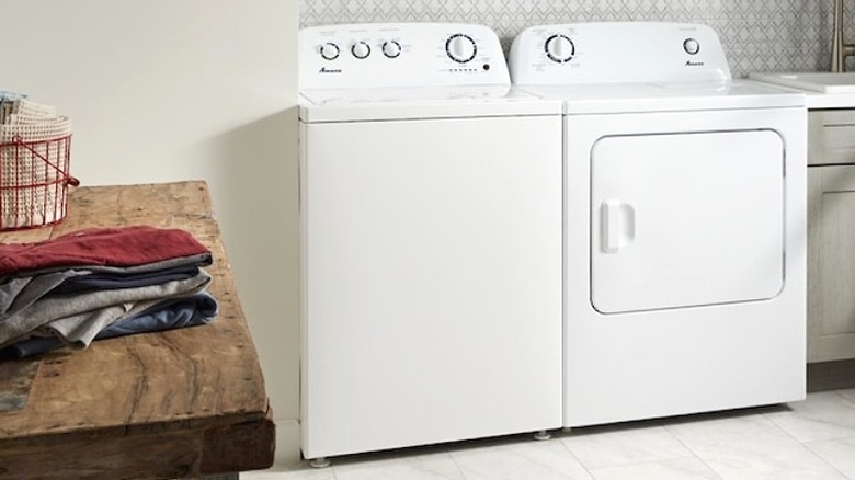 An Amana top-load washer/dryer set in a laundry room