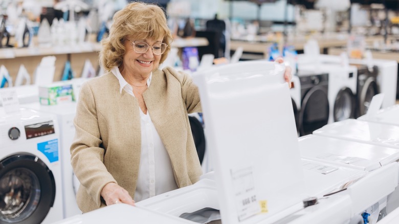 A woman shopping for top-loading washing machines
