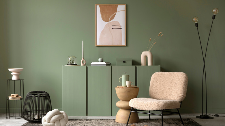 A room with sage green wall and furniture.