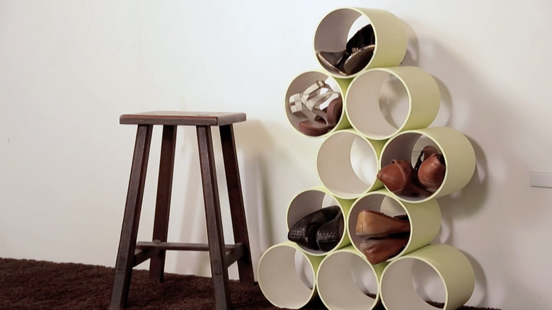 A green shoe rack made from spare PVC pipes