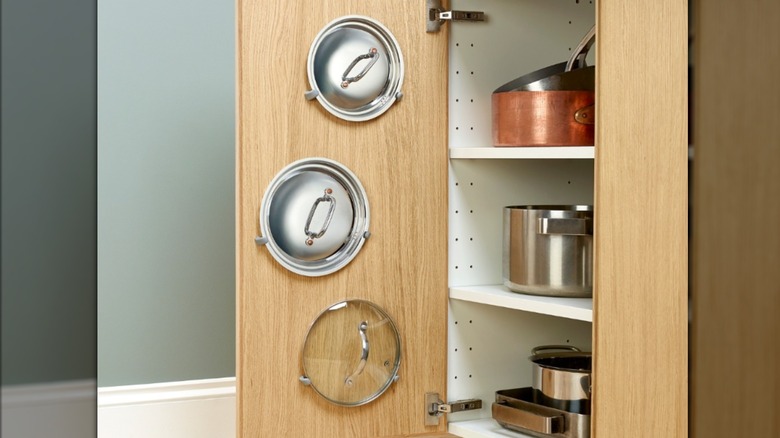 Pot lids hung on the inside of a cabinet drawer