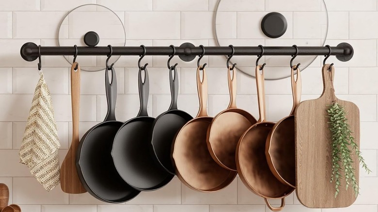 Two pot lids tucked behind a rail for hanging pots