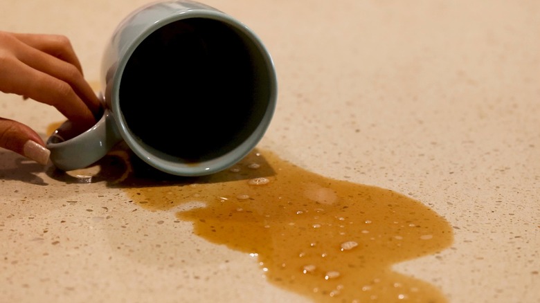 Spilled coffee cup on stone countertop