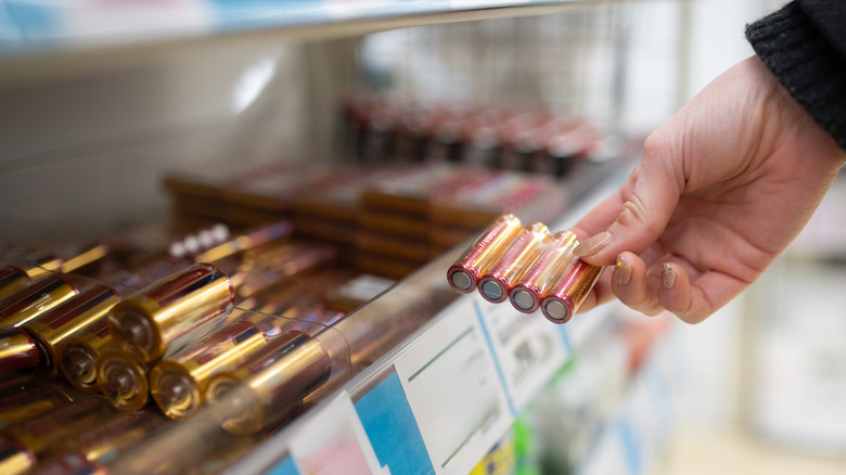 person holding a small package of batteries