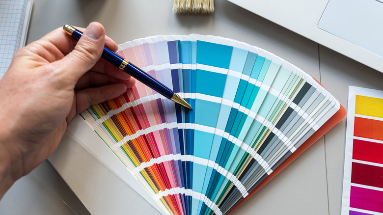 Person looking through paint color swatches for a DIY