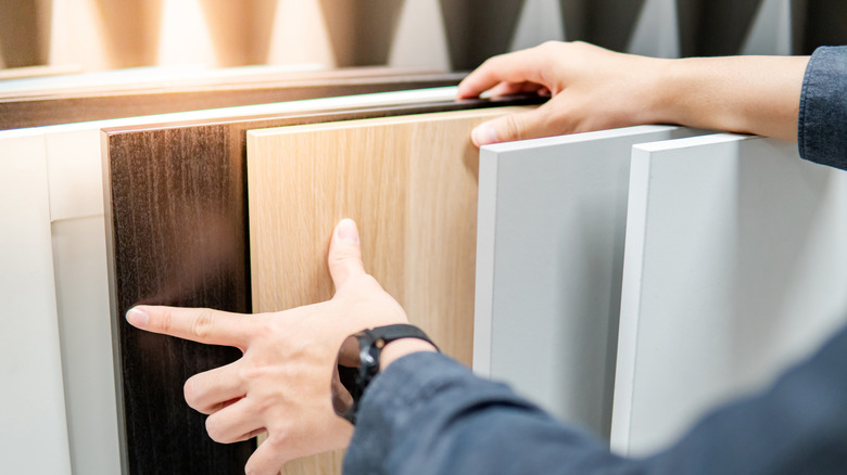 Person browsing a selection of pre-fabricated cabinet panels