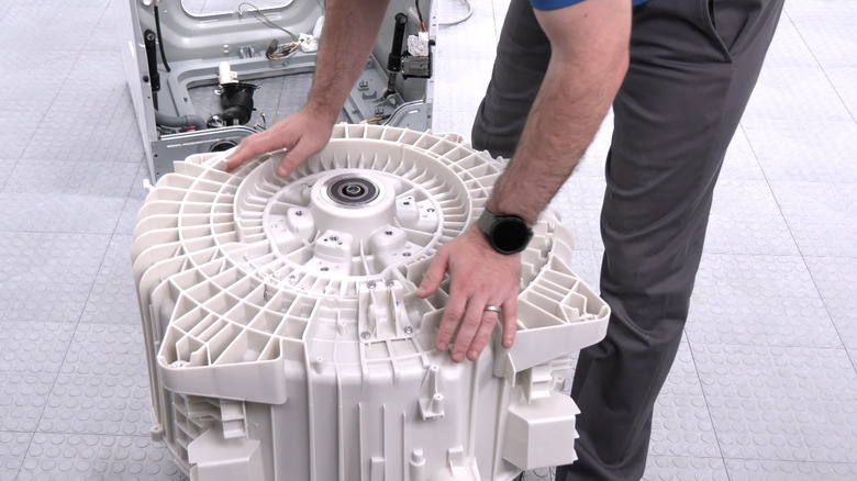 Inserting the spin basket into the rear tub assembly of an LG washing machine