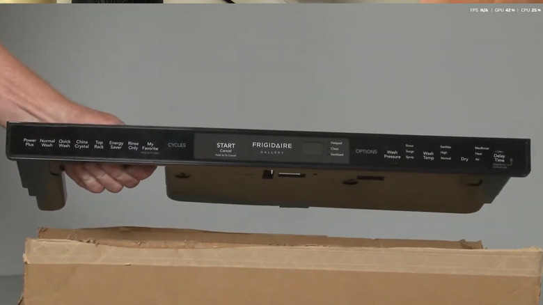 hand holding control panel for a Frigidaire dishwasher over a cardboard box