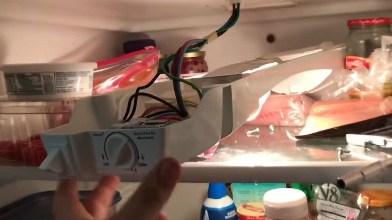 Hand showing location of frozen drain tube on Kenmore freezer-on-top refrigerator
