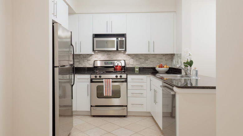 small white kitchen with stainless steel appliances