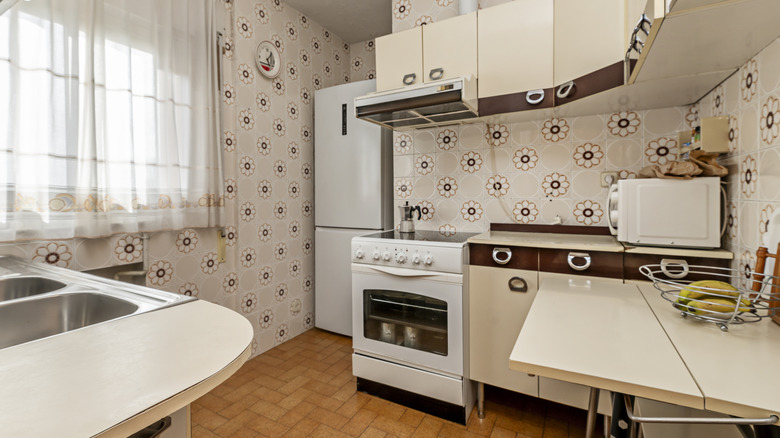 outdated tiled kitchen with white appliances