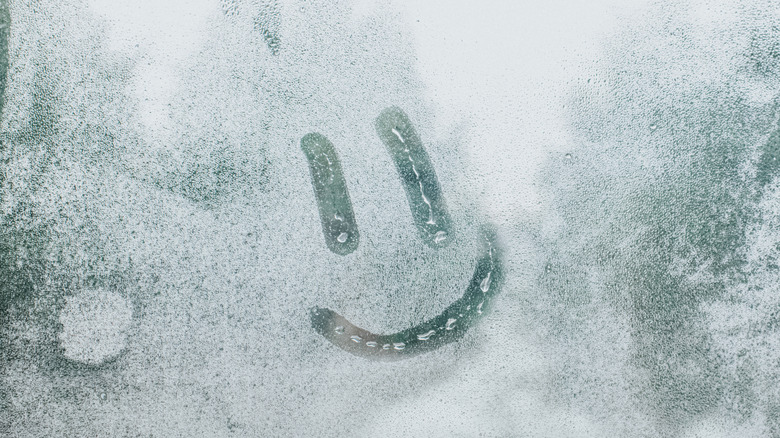 Smiley face drawn in steamy glass