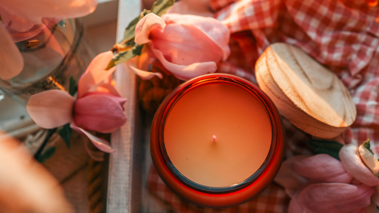 A candle next to fresh spring blossoms
