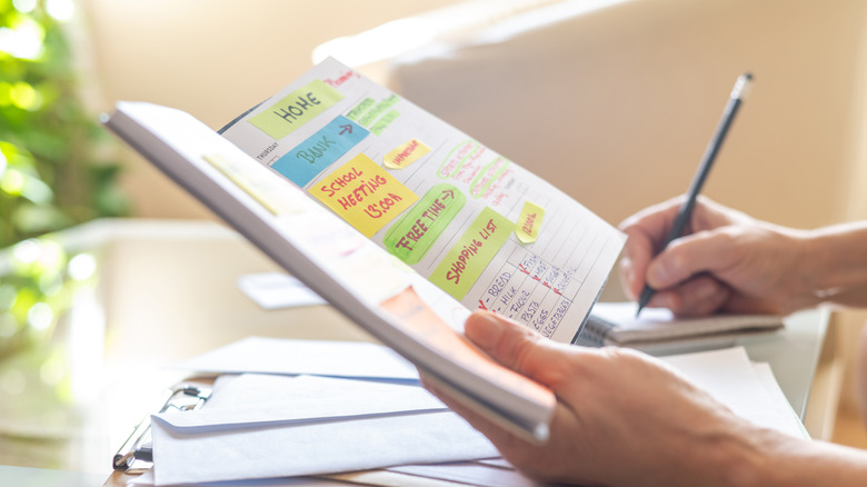 Person looking at to-do list written in their notebook