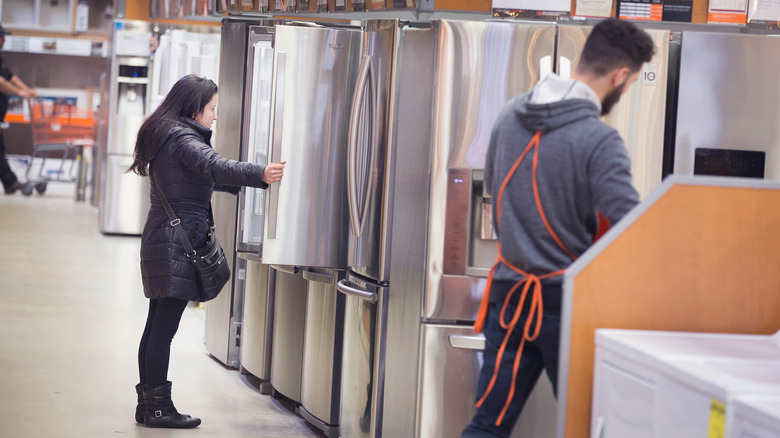 A woman looks at a refrigerator on display at Home Depot