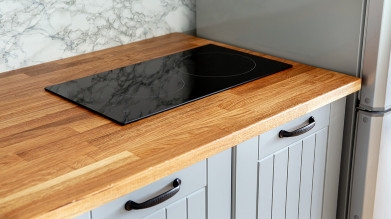 Butcher block countertop with induction cooktop.