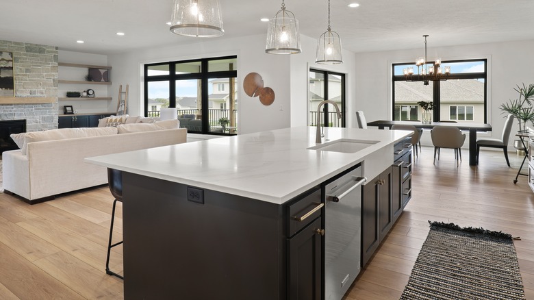 A large kitchen island with appliances, lighting, and seating