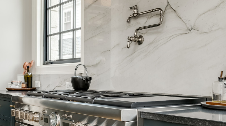 A pot filler in a kitchen with commercial appliances