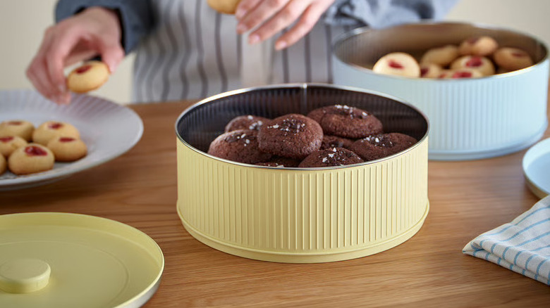 person filling a pair of IKEA BETTHAJ food storage containers with cookies