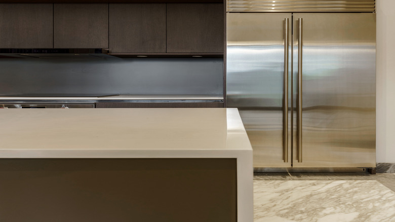 dark wooden cabinets in a kitchen with a stainless steel fridge