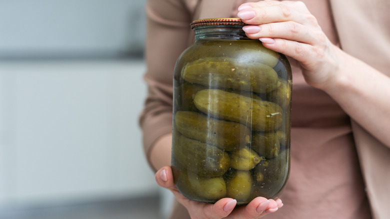 woman holding a jar of pickles